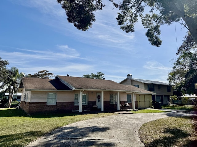 view of front of house featuring concrete driveway, brick siding, and a front yard