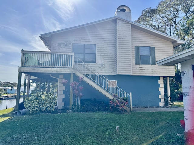 view of front of house with a front lawn, stairway, and stucco siding