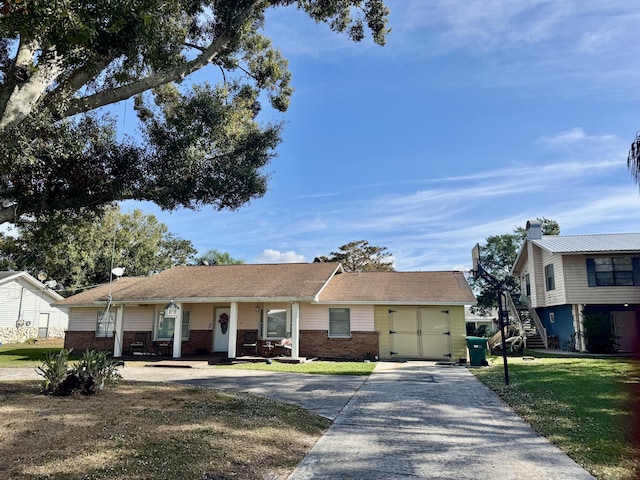 view of front facade featuring driveway, stairway, a front lawn, and brick siding