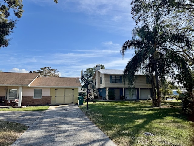 view of front of house with a garage, driveway, brick siding, and a front yard