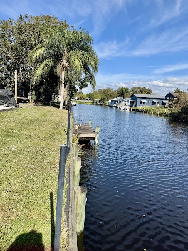 view of dock featuring a water view and a yard