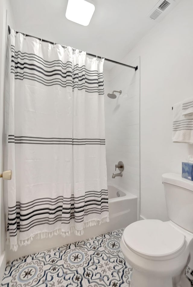 bathroom with tile patterned flooring, shower / bath combination with curtain, and toilet