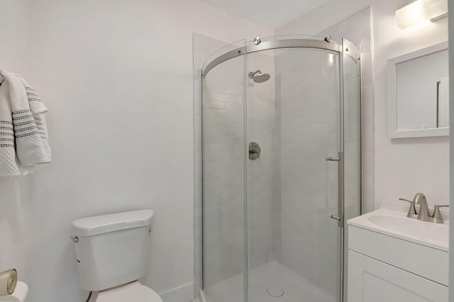 bathroom featuring vanity, toilet, and a shower with door