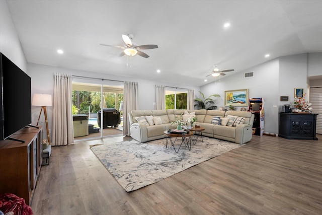 living room with hardwood / wood-style flooring, ceiling fan, and lofted ceiling