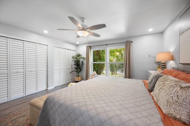 bedroom featuring ceiling fan, wood-type flooring, and multiple closets