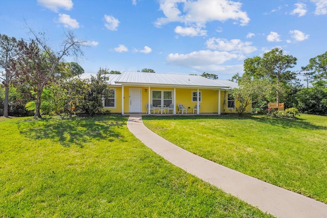 ranch-style home featuring covered porch and a front yard