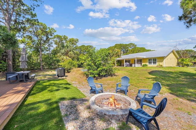 view of yard featuring an outdoor fire pit and a wooden deck