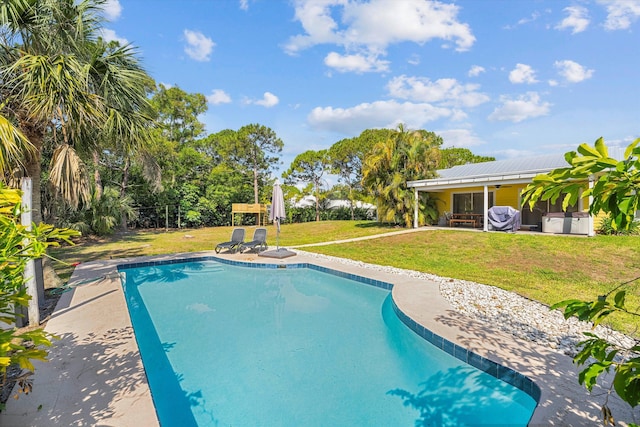 view of swimming pool featuring a lawn and a patio area