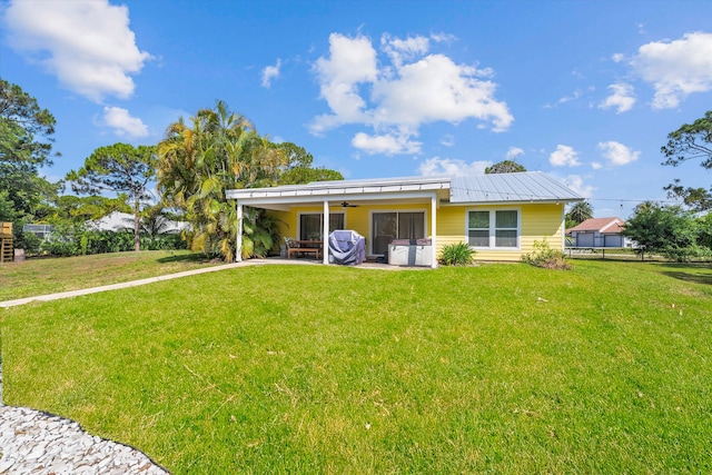 view of front of house with ceiling fan, a front lawn, and a patio