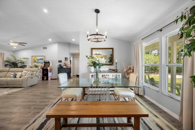 dining room with hardwood / wood-style flooring, ceiling fan with notable chandelier, and lofted ceiling