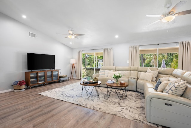 living room featuring ceiling fan, plenty of natural light, wood-type flooring, and lofted ceiling