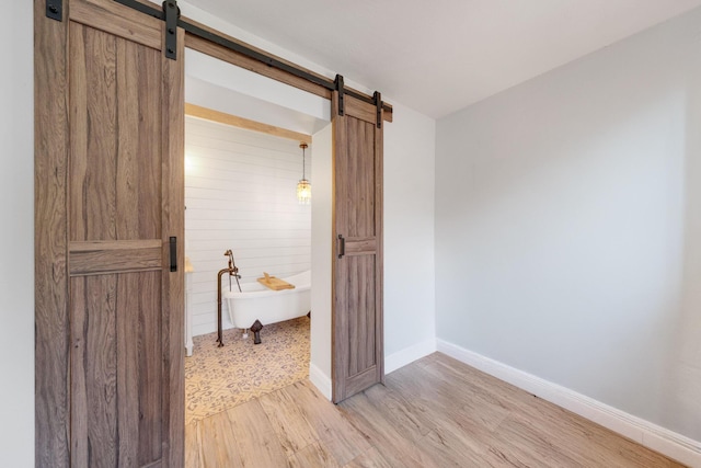 bathroom featuring wooden walls, wood-type flooring, and a bath