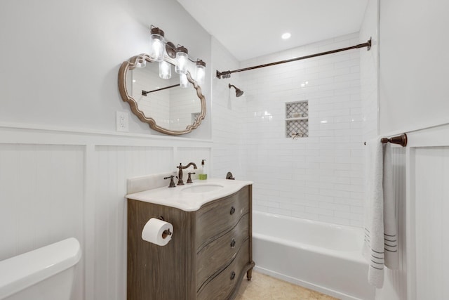 full bathroom featuring tiled shower / bath, vanity, and toilet