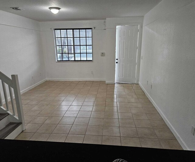 entrance foyer featuring a textured ceiling and light tile patterned flooring