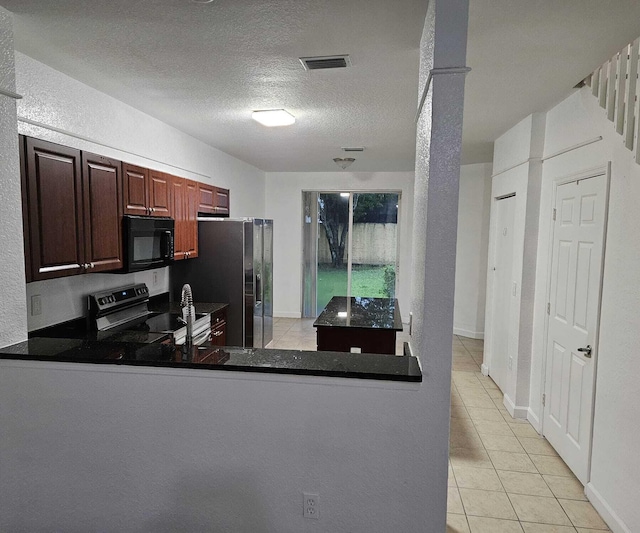 kitchen with electric range, stainless steel fridge, a textured ceiling, light tile patterned flooring, and kitchen peninsula