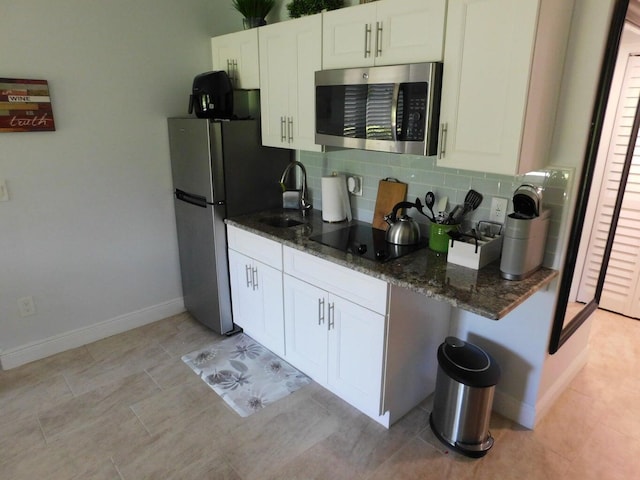 kitchen featuring white cabinets, appliances with stainless steel finishes, tasteful backsplash, and sink