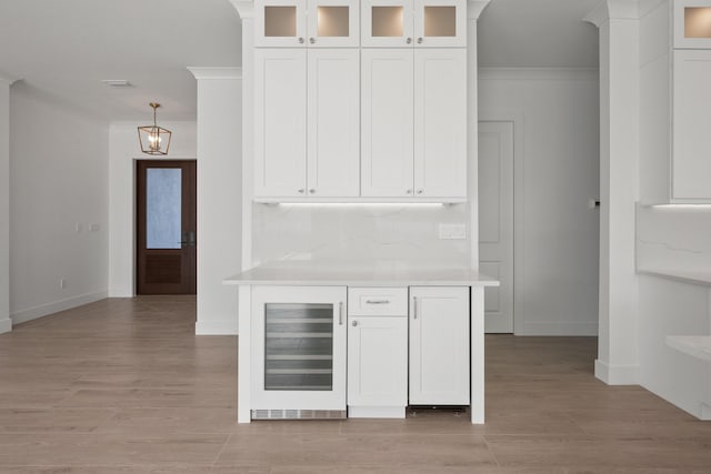 bar featuring wine cooler, decorative backsplash, white cabinets, and ornamental molding