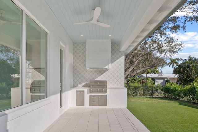 view of patio with exterior kitchen, fence, area for grilling, and a ceiling fan