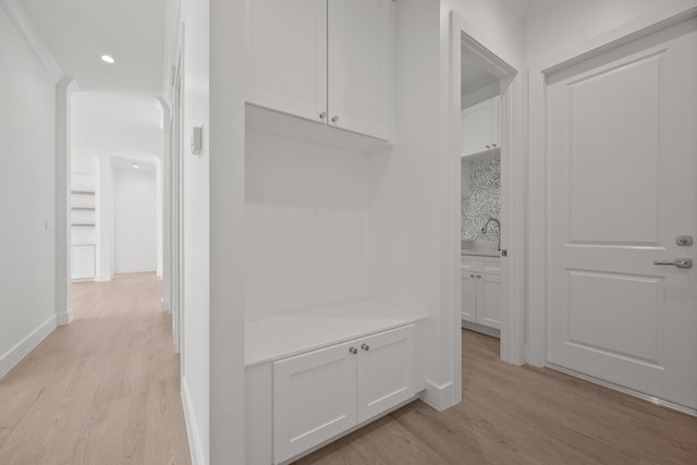 hall featuring light hardwood / wood-style floors and ornamental molding