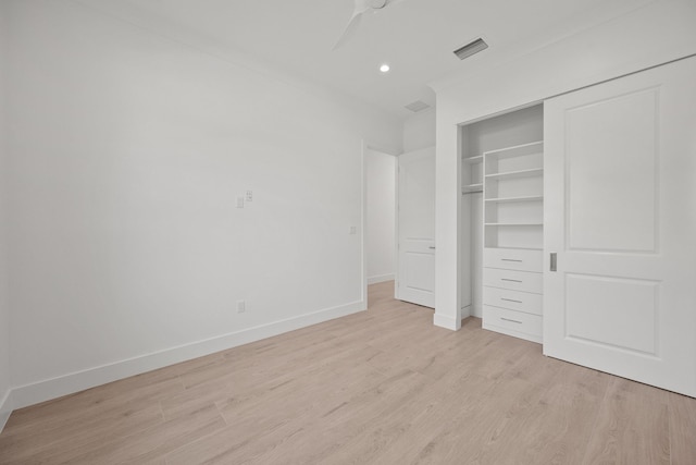 unfurnished bedroom with ceiling fan, a closet, ornamental molding, and light hardwood / wood-style flooring