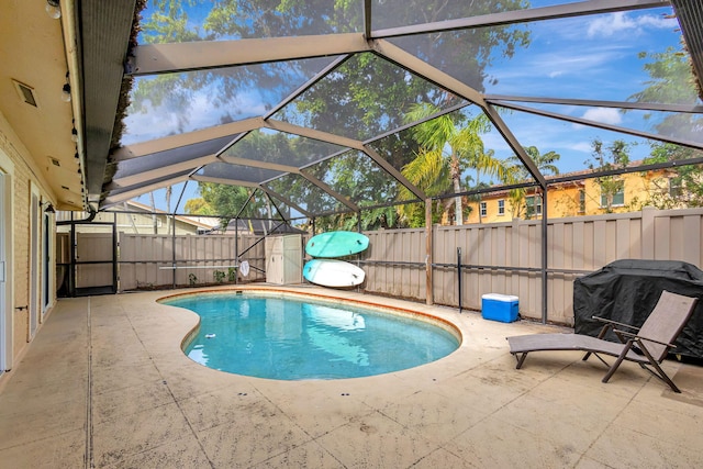 view of pool with a lanai, area for grilling, and a patio area