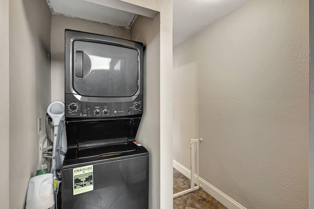 laundry room featuring stacked washer and dryer and a textured ceiling