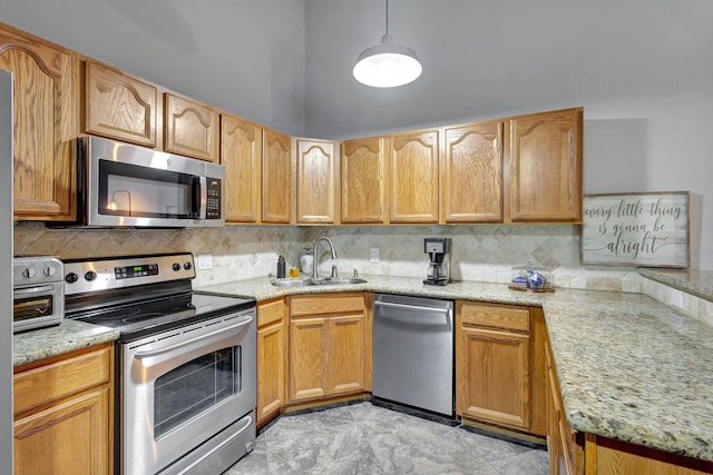 kitchen with light stone countertops, appliances with stainless steel finishes, backsplash, and sink