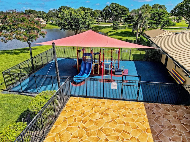 view of playground with a lawn and a water view