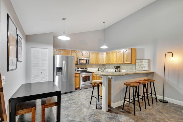 kitchen with kitchen peninsula, a kitchen bar, backsplash, stainless steel appliances, and decorative light fixtures