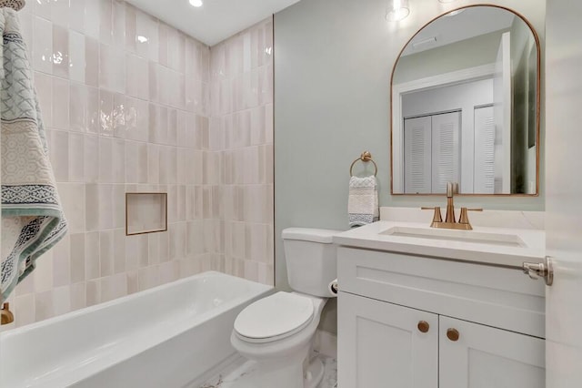 full bathroom with vanity, tiled shower / bath combo, and toilet