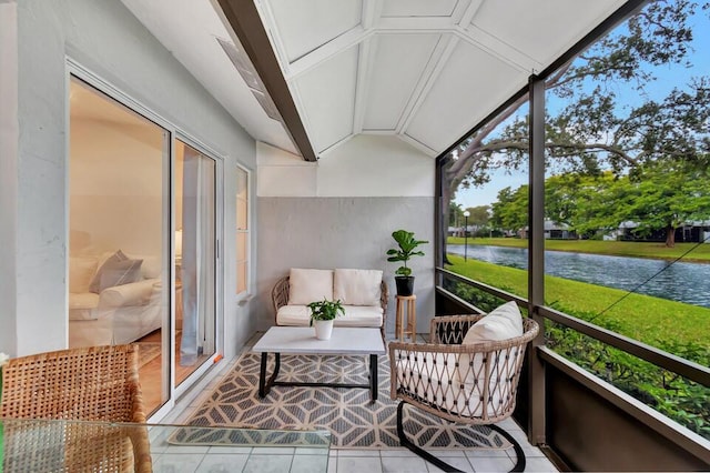 sunroom / solarium featuring a water view and vaulted ceiling