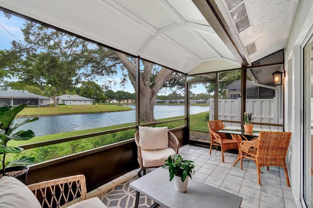 sunroom / solarium with a water view and vaulted ceiling