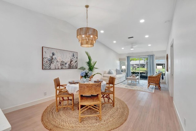 dining space with light wood-type flooring, vaulted ceiling, and ceiling fan