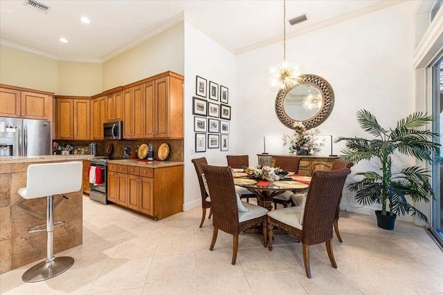 kitchen featuring decorative backsplash, appliances with stainless steel finishes, crown molding, light tile patterned floors, and hanging light fixtures