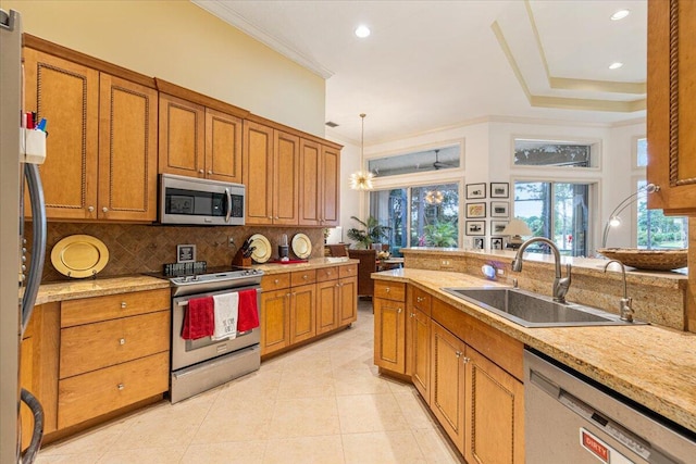 kitchen with pendant lighting, backsplash, sink, crown molding, and stainless steel appliances