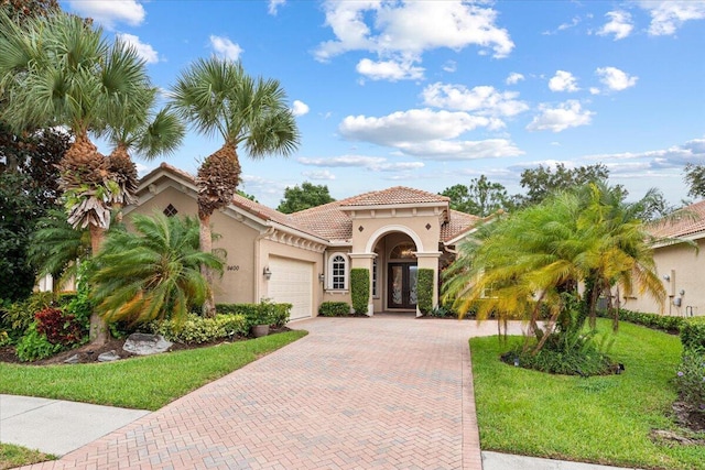 mediterranean / spanish-style house with a front lawn and a garage