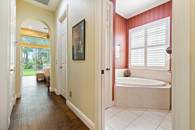 corridor with wood-type flooring and ornamental molding