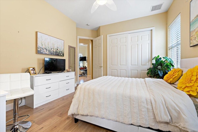 bedroom featuring ceiling fan, a closet, and light wood-type flooring