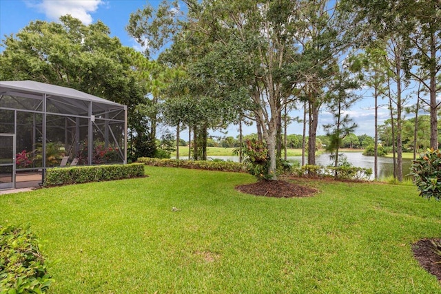 view of yard featuring a water view and glass enclosure