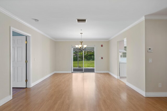 spare room featuring light wood-type flooring, ornamental molding, and an inviting chandelier