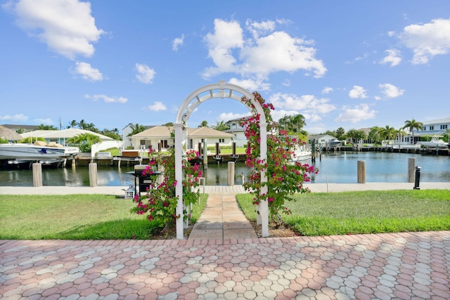 view of dock with a water view and a yard