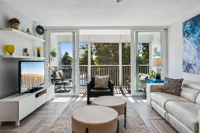 living room featuring floor to ceiling windows, plenty of natural light, a textured ceiling, and light parquet floors