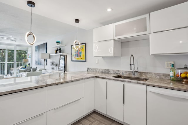 kitchen featuring white cabinets, dishwasher, sink, and pendant lighting