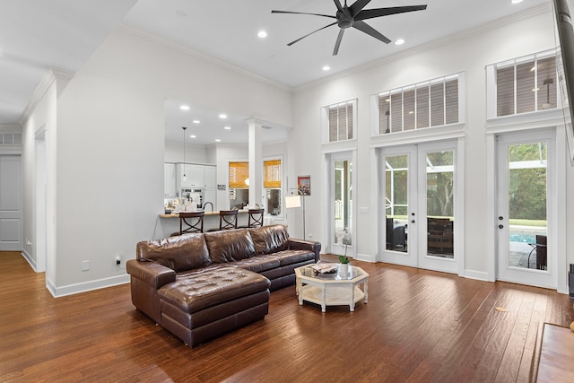 living room featuring french doors, crown molding, a towering ceiling, and hardwood / wood-style flooring