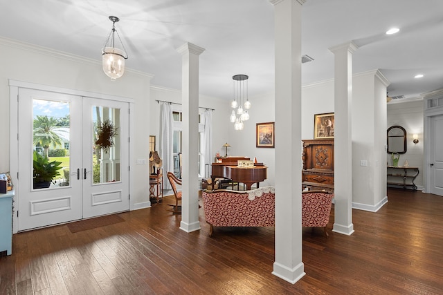 foyer featuring french doors, decorative columns, crown molding, a notable chandelier, and dark hardwood / wood-style floors