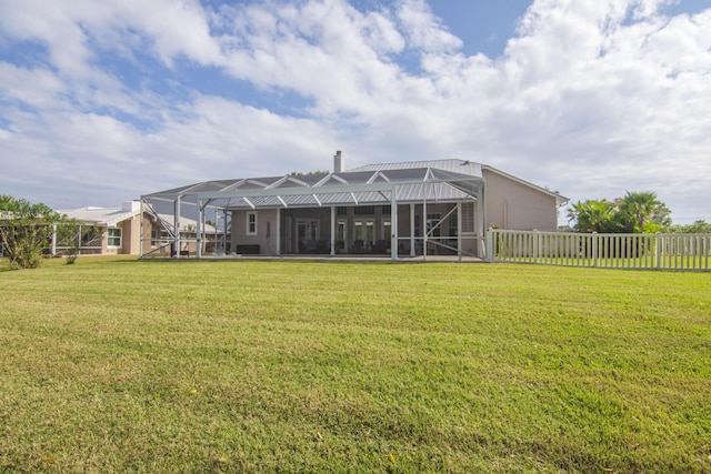 back of house featuring a yard and glass enclosure