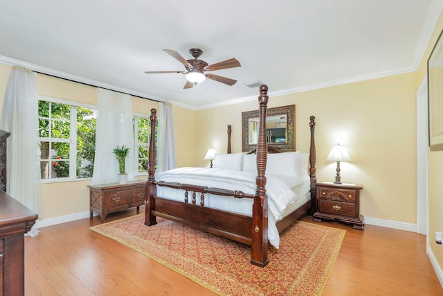 bedroom featuring ceiling fan, light wood-type flooring, and crown molding