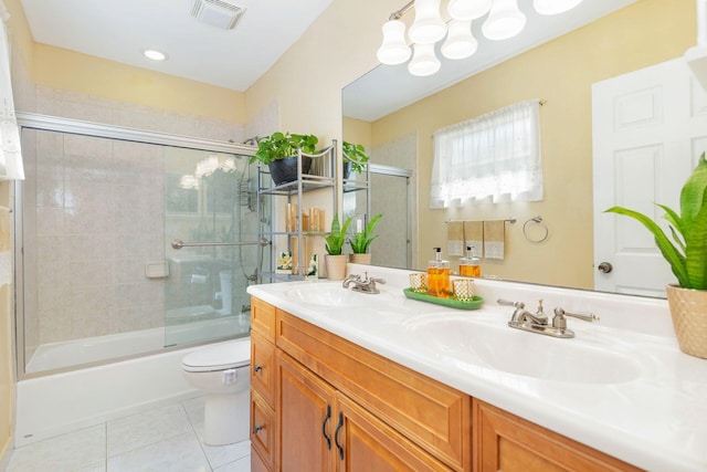 full bathroom featuring tile patterned floors, vanity, toilet, and shower / bath combination with glass door