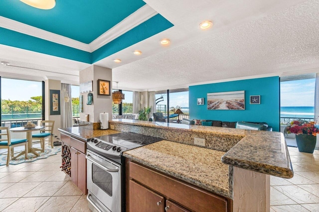 kitchen featuring stainless steel range with electric stovetop, a textured ceiling, crown molding, a water view, and a kitchen island