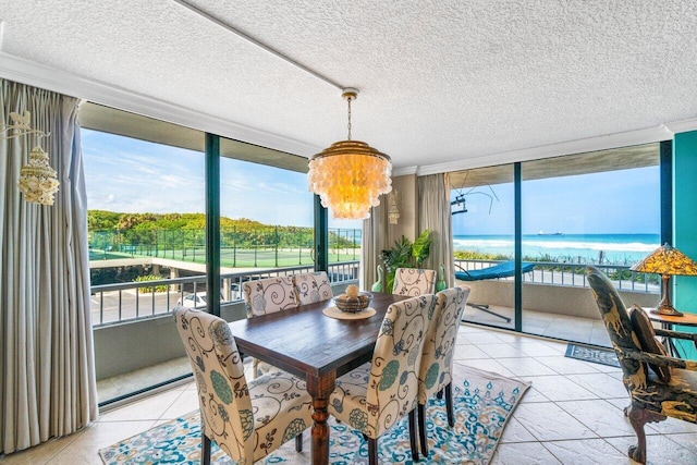 tiled dining room featuring a water view, a chandelier, and ornamental molding